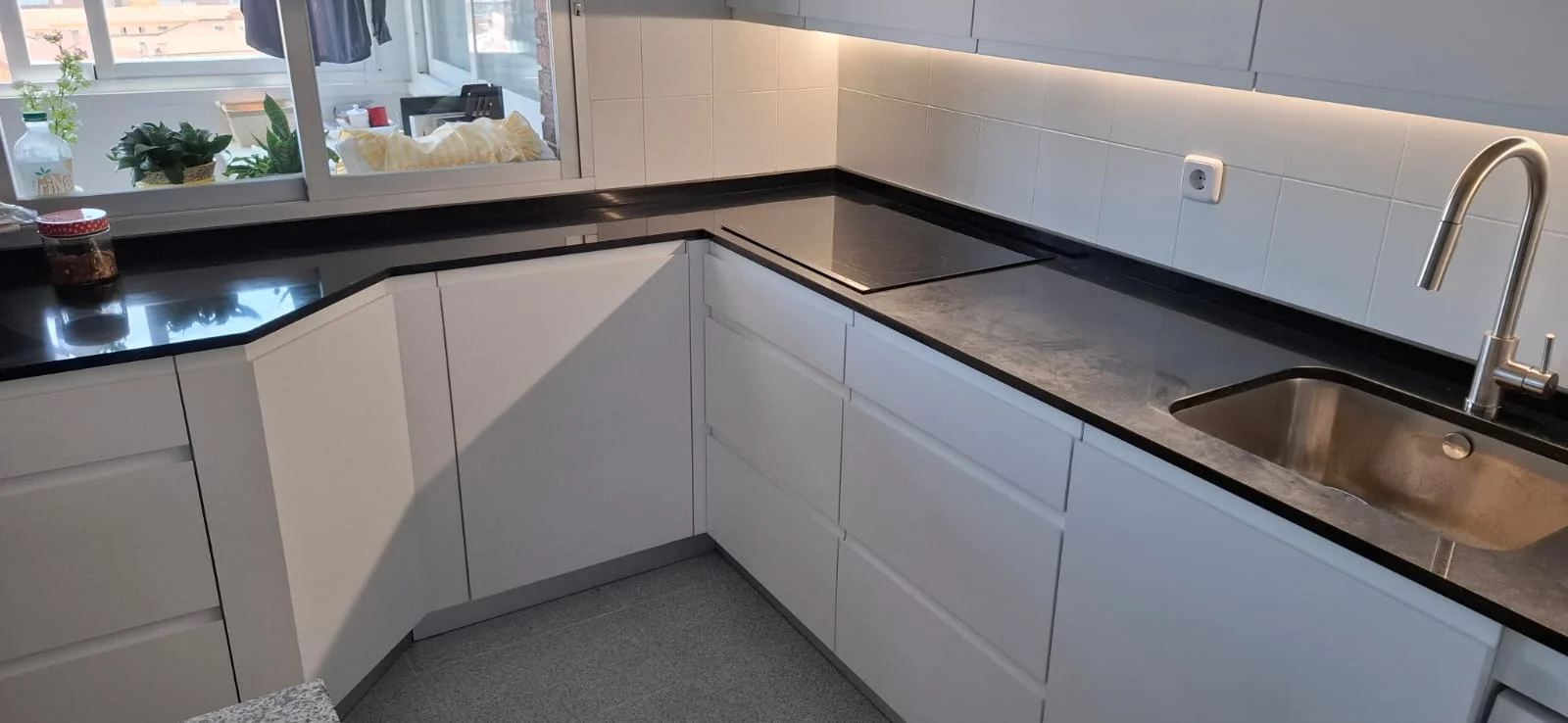Cocina blanca con encimera negra